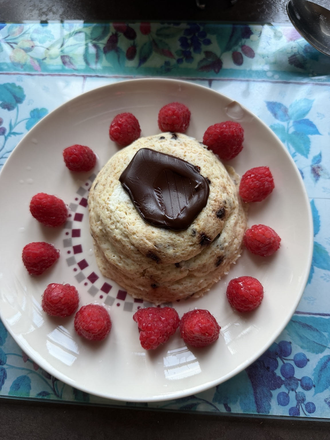 Pancakes au chocolat entourés de framboises